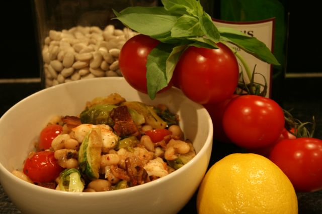 White beans with shrimp, brussel sprouts and bacon in a bowl