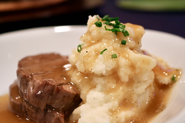 Mashed potatoes and beef covered in gravy
