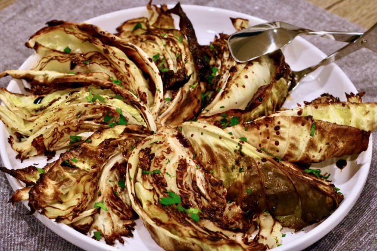 roasted cabbage wedges on a platter drizzled with balsamic vinegar