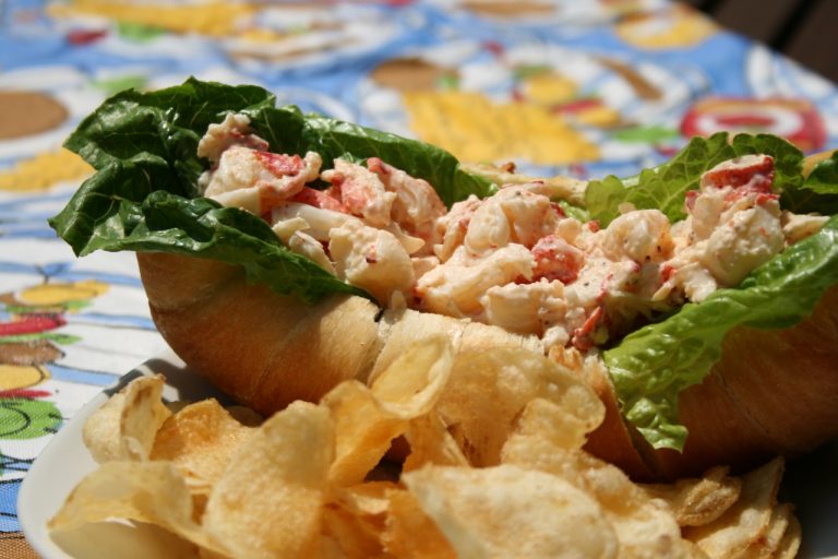 Lobster Roll with potato chips on a picnic table