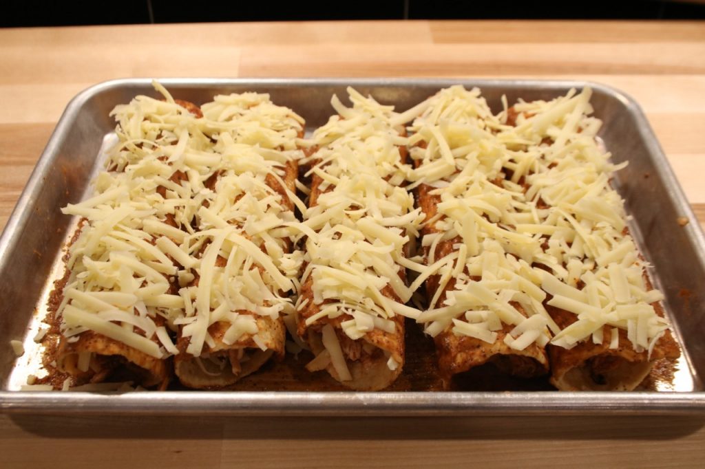 Enchiladas smothered in cheese before baking
