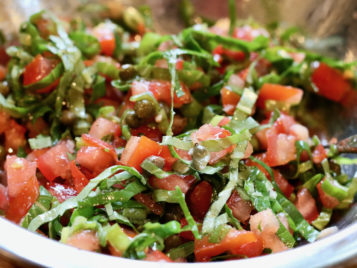 Chopped tomatoes with capers and basil in a bowl