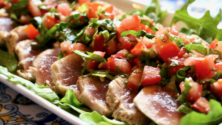 Grilled tuna with tomatoes & capers on platter