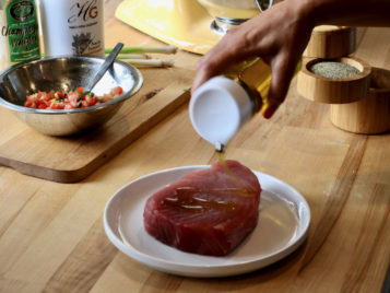 olive oil being put on tuna steak