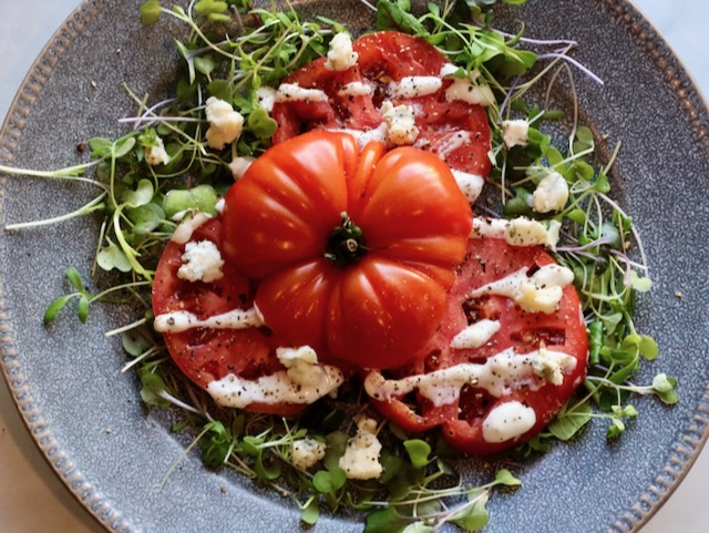 heirloom tomato with blue cheese dressing drizzled over