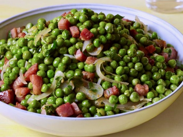 Michael Symon's sweet peas and savory pancetta with sliced onions in a bowl