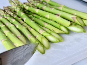 Asparagus being sliced on an angle