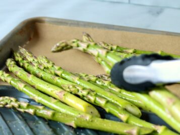 Using tinges to move Asparagus from a plate used for seasoning to a parchment lined sheet pan