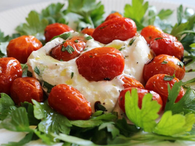 Slow Roasted cherry tomatoes served over with Burrata with herbs and olive oil for an elevated Caprese salad