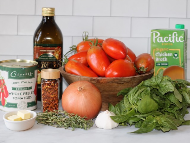 Ingredients for Ina Garten tomato soup, including plum tomatoes, fresh basil, onion, garlic, thyme, butter and olive oil