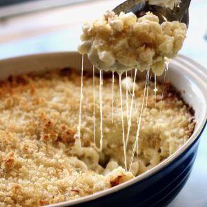 Mac & Chesse being lifted out of bowl with stretching cheese