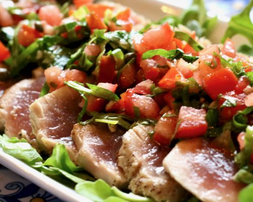 Grilled tuna with tomatoes & capers on platter