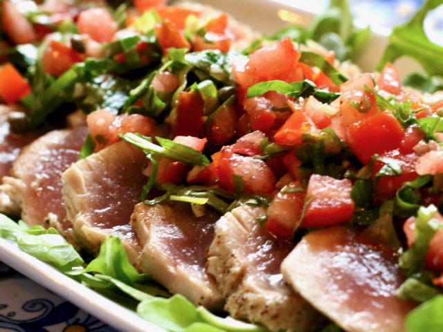 Grilled tuna with tomatoes & capers on platter