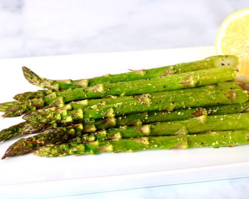 Roasted Asparagus arranged artfully on a white serving platter