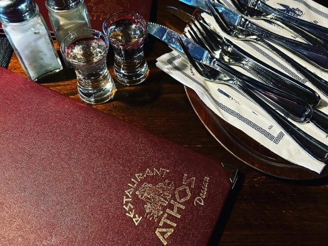 Athos Restaurant menu with 3 place settings, salt, pepper and shot glasses