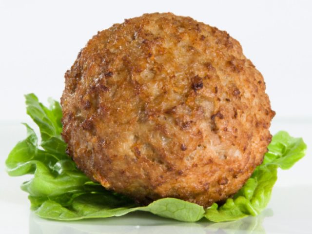 A golden-brown, cooked meat patty, the gift of the perfect meatball tip, resting on a fresh green lettuce leaf.