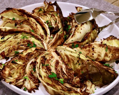 roasted cabbage wedges on a platter drizzled with balsamic vinegar