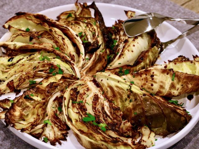 roasted cabbage wedges on a platter drizzled with balsamic vinegar