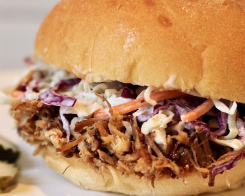 Slow Cooker Pulled Pork on a roll with coleslaw